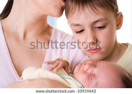 young mother holds the baby and kissing his son