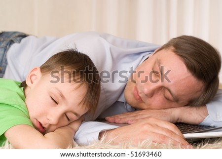 father sleeps with son on laptop