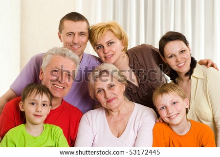 portrait of a happy family of seven people on a light background