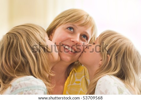 two daughters together kissing his lucky mom