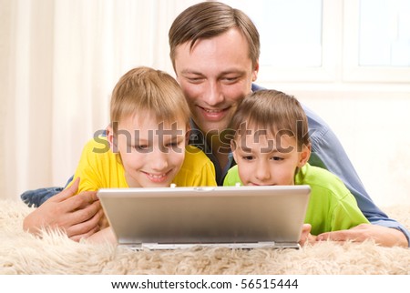 صور من الحياة  اليومية في الدول الاروبية Stock-photo-father-with-his-sons-is-on-the-carpet-with-laptop-56515444
