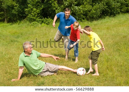 happy family playing soccer on the grass