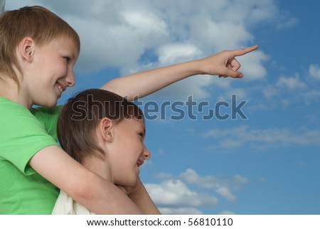 two happy brothers stand against the sky