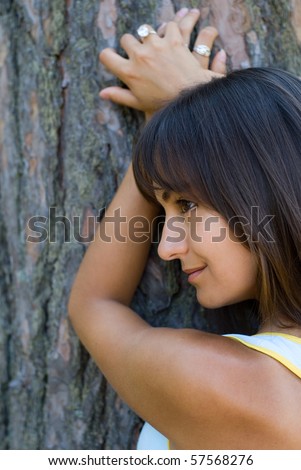 Nice girl leaning against the tree