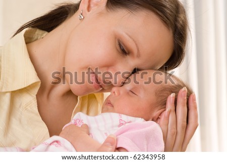 happy mom holds the baby on a white