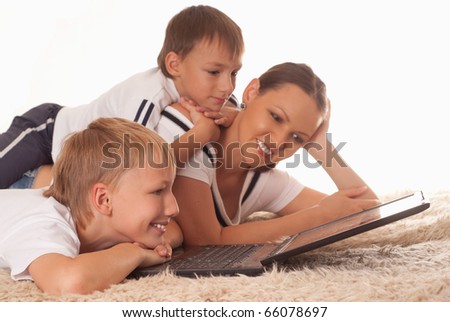 mom with his sons is on the carpet with laptop