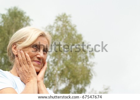 older woman stands on the sky