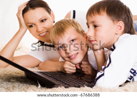 mom with his sons on the carpet with laptop