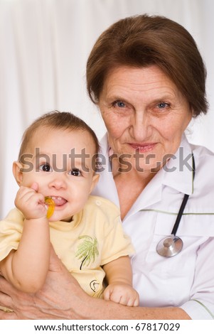 elderly doctor holding a newborn in her arms