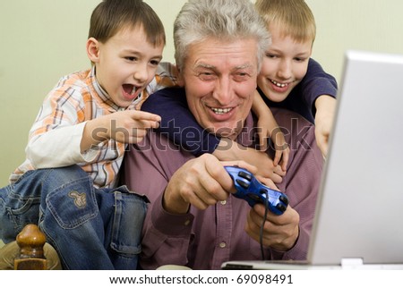 happy grandparent with their grandchildren play on the computer