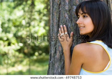 nice woman standing by a tree on the nature