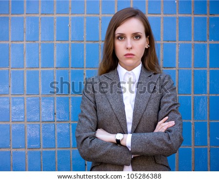Diptych of portraits young sad pretty woman with arms crossed near the blue wall. Outdoor, office fashion, street fashion