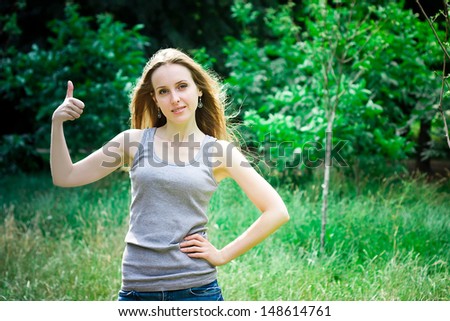 Young woman thumbs up in a forest