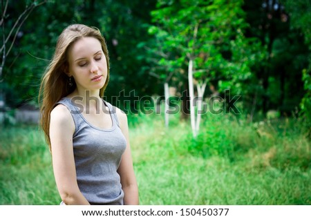 Young woman dreams in a forest with closed eyes