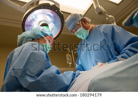A surgeon operating in the operating theater.