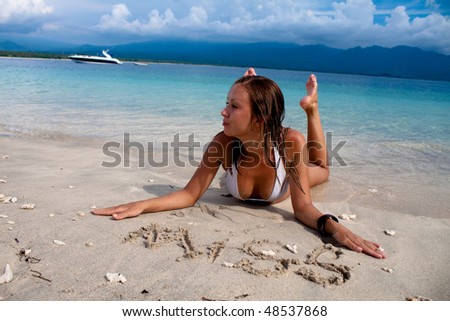 beautiful woman relaxing on a tropical beach with send miss with the boat view
