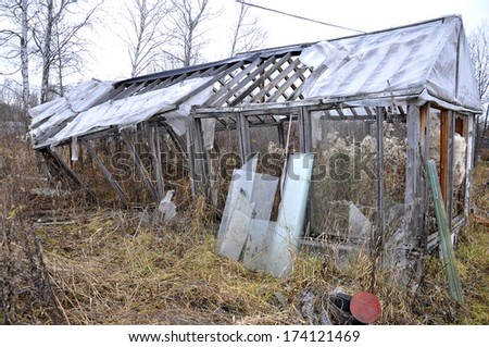 the old broken wooden greenhouse in a kitchen garden