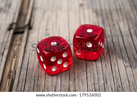 Pair of thrown red dices on old wooden table showing two ones - snake eyes