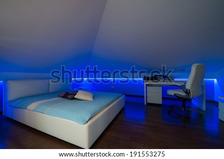 Bedroom in luxury loft apartment - shot in low light to highlight the atmosphere of blue led lights
