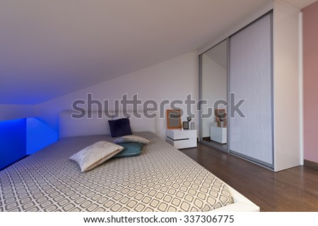 Bedroom in loft apartment - shot in low light to highlight the atmosphere of blue led lights