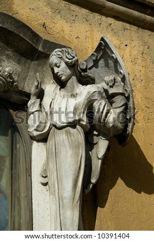Statue of a woman holding a shield. Taken on a building facade in the Vatican