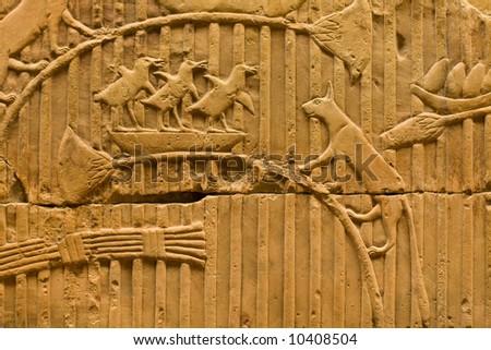 An Egyptian rock carving of a cat about to attack a bird nest