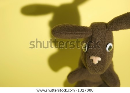 Little toy rabbit on a yellow background.