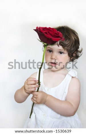 Little girl holding a Rose with a Ring around the stem. Soft focus, focus on the hands with ring and stem.