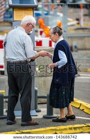 STUTTGART, GERMANY - June 15, 2013: A senior couple is paying at a ticket machine for parking at the construction site of Stuttgart21 at the main station on June 15, 2013 in Stuttgart, Germany.