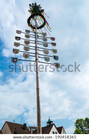 OSTFILDERN-SCHARNHAUSEN, GERMANY - MAY 1, 2014 - A recently mounted maypole with plaques representing the various professions and crafts of the town on May, 1,2014 in Ostfildern-Scharnhausen, Germany.