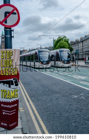 EDINBURGH, SCOTLAND - June 1, 2014: Signs alerting the public to watch out for trams on June 1, 2014 in Edinburgh, Scotland. The city launched its tram public transport system the day before and since