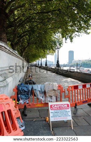 LONDON, UK - SEPTEMBER 28, 2014: Warning sign filming in progress at a film set on location at the river Thames on September 28, 2014 in London, UK.