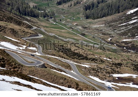 Mountain pass road through snow covered rocks on Spluegen Pass in Switzerland, Europe