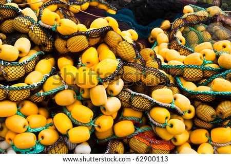 Closeup on fishing net with yellow floaters stored on fisher boat during the day