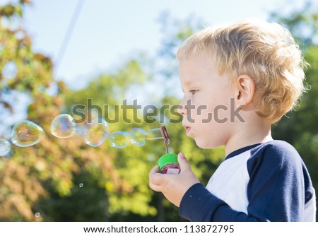 Child making soap bubbles outside