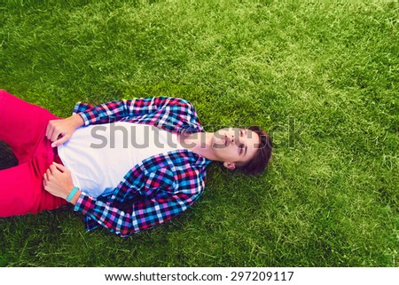Young man lying on the grass, enjoying
