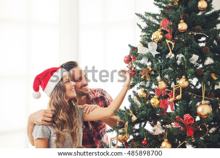 Cute, young couple decorating a Christmas tree