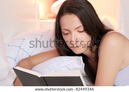 Girl reading a book in bed