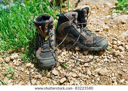 Walking boots in front of a mountain stream in a forest landscape
