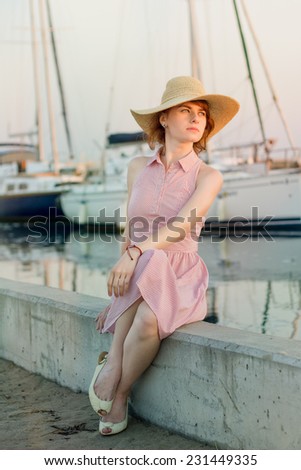Lonely teenage lady sitting on the dock waiting