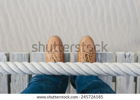Rope barrier on beach with legs
