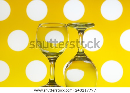 Wine glasses on yellow dots background