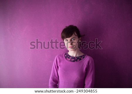 Beautiful young woman in pink sweater on pink background.