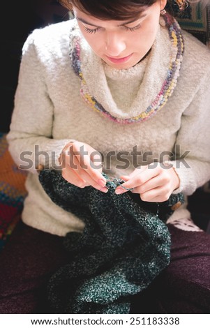 Knitting woman. Selective focus on face and needle. Toned with filter.