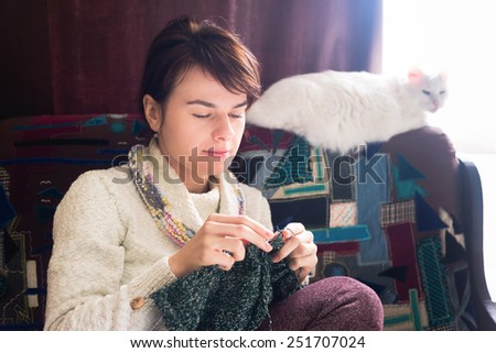 Knitting woman with cat. Soft focus. Toned with filter.