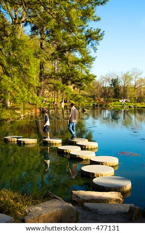 Father and son in    Japanese garden on stepping stones