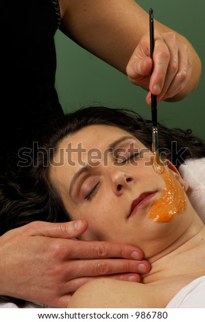 Facial Masque of organic carrot,pumpkin,lime,and orange being applied by esthetician at Mind & Body Boutique Spa