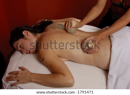 Masseuse Massaging with Thai Compresses at Mind and Body Boutique