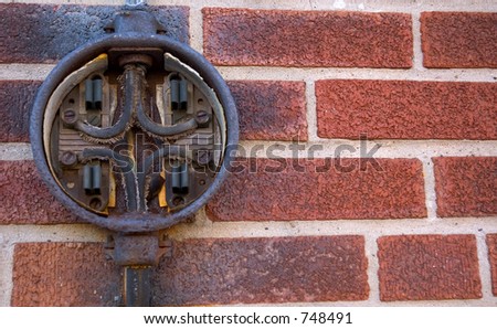 Old electrical box on a brick wall.