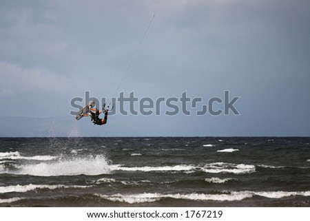 man performing kite surfing stunt